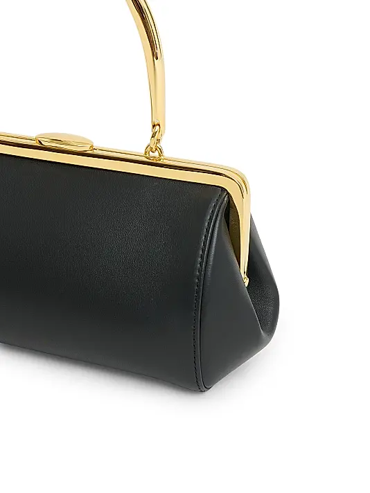 Formstabile Mini‑Handtasche mit goldener Rahmenverzierung, Druckknopf und Obergriff