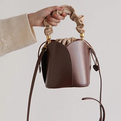 Eimer‑Handtasche aus braunem veganem Leder mit Rosenblatt‑Prägung, gerafftem Griff und herzförmigem Schnürzug‑Dekor