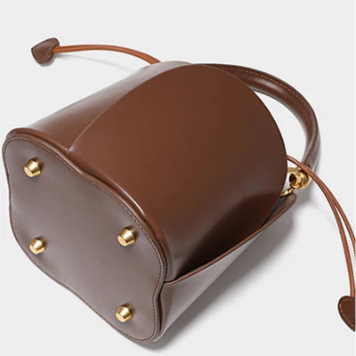 Eimer‑Handtasche aus braunem veganem Leder mit Rosenblatt‑Prägung, gerafftem Griff und herzförmigem Schnürzug‑Dekor